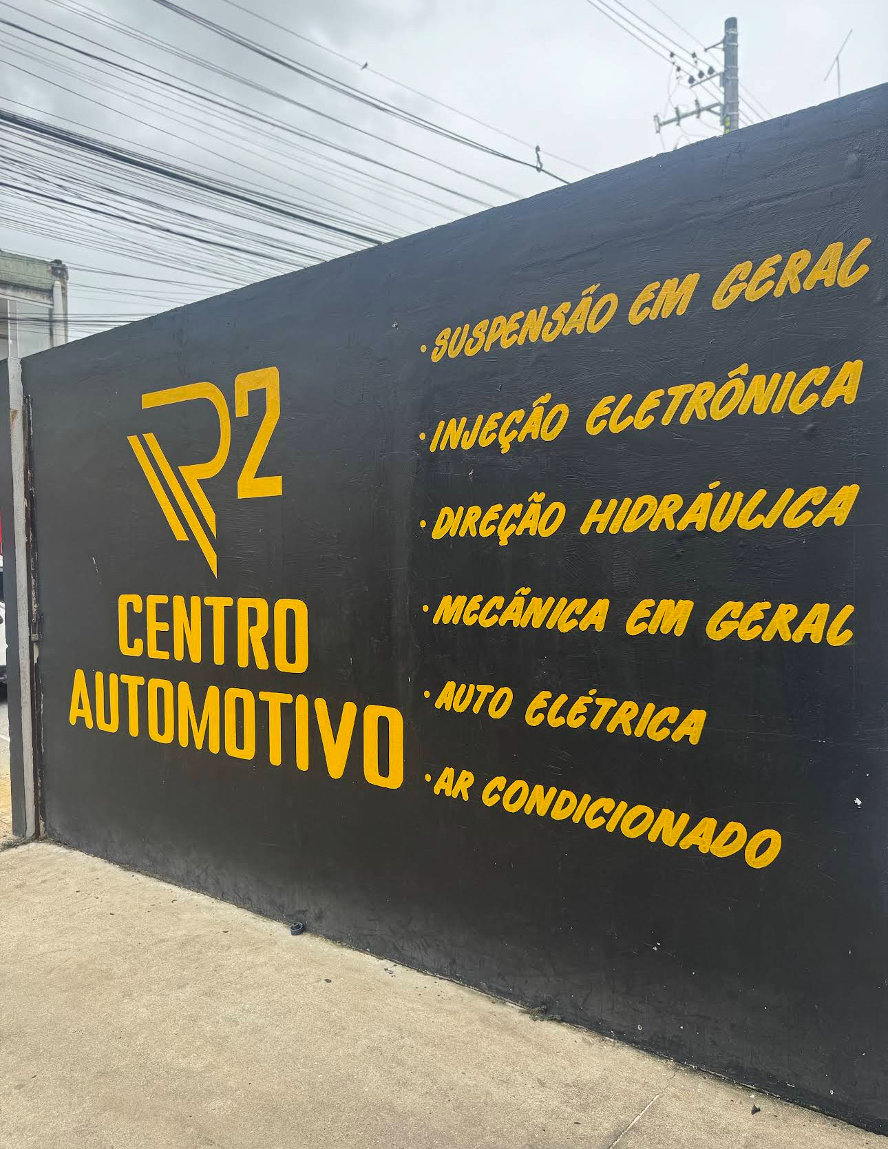 Muro com a marca e os serviços da R2 na R2 Centro Automotivo em Serra ES